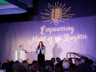 Punam doing standup comedy on stage